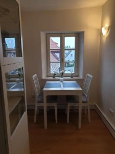 uma mesa de jantar com 2 cadeiras e uma janela em Torhaus Rattelsdorf - Wohnung Lilie em Rattelsdorf