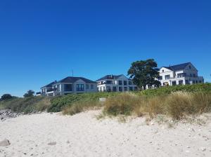 a row of houses on top of a beach at Fehmarn-OstseeferienStrandresidenz VogelflugApp 10 in Fehmarnsund