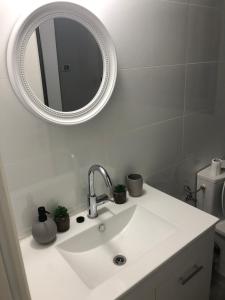 a white bathroom with a sink and a mirror at דירת נופש ׳חושן׳ in Eilat +4 photos
