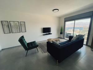 a living room with a couch and chairs and a television at דירת נופש ׳חושן׳ in Eilat