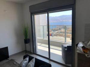 a living room with a sliding glass door with a view at דירת נופש ׳חושן׳ in Eilat