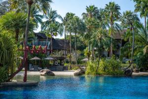 a resort with a pool and palm trees at The Slate, Phuket in Nai Yang Beach