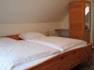 ヴァンガーラントにあるFerienwohnung Zum alten Friesen OKKOのベッドルーム1室(木製ベッド1台、木製ドレッサー付)