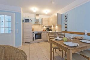 a kitchen with a wooden table and a dining room at Villa Ostseestern, FW 2 in Zingst