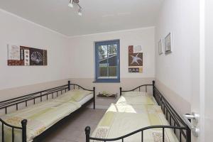 2 łóżka pojedyncze w pokoju z oknem w obiekcie Villa Ostseestern, FW 2 w Zingst
