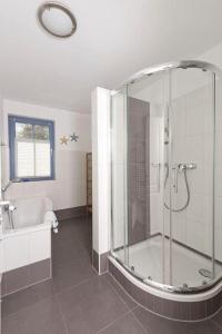 a bathroom with a shower and a tub and a sink at Villa Ostseestern, FW 2 in Zingst