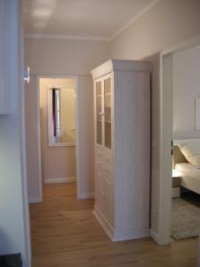 プレローにあるResi F3の白いキャビネット付きのベッドルーム1室(ベッド1台付)