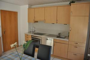 uma cozinha com armários de madeira, um lavatório e um fogão em Ferienhaus "Antonia" - a47030 em Witzenhausen