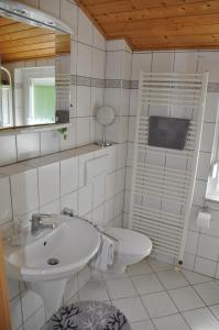 uma casa de banho branca com um lavatório e um WC em Ferienhaus "Antonia" - a47030 em Witzenhausen