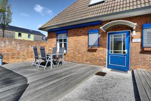 a deck with chairs and a blue door on a brick building at Altes Wasserwerk, FW 9 in Zingst