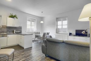 a kitchen and living room with a couch and a table at Altes Wasserwerk, FW 9 in Zingst