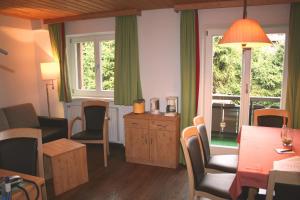 sala de estar con mesa, sillas y ventana en Fockenstein, en Bad Wiessee
