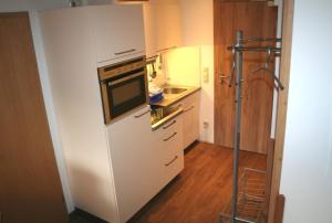 cocina con armarios blancos y microondas en Fockenstein, en Bad Wiessee