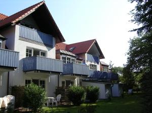 une maison avec des balcons bleus sur son côté dans l'établissement Gästehaus Whg 1, à Prerow