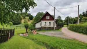 a small white house with a red roof at Chata u potoka in Lázně Bělohrad