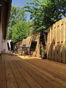 a deck with chairs and a table and a fence at Achterdeck FW 2 in Zingst
