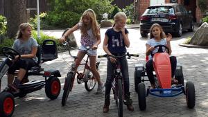 a group of children riding bikes and cars at Gästehaus Bommelsen - FEWO 1 in Bomlitz