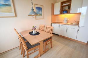 eine Küche und ein Esszimmer mit einem Tisch und Stühlen in der Unterkunft Zur schönen Aussicht - FW 5 in Dahme
