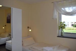 a small bedroom with a bed and a window at Fehmarnstrand 78 RH 7 in Staberdorf