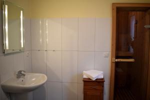 een witte badkamer met een wastafel en een spiegel bij Fehmarnstrand 78 RH 7 in Staberdorf