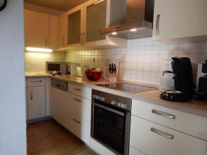 een keuken met witte kasten en een fornuis met oven bij Ferienhaus Am Nordstrand in Prerow