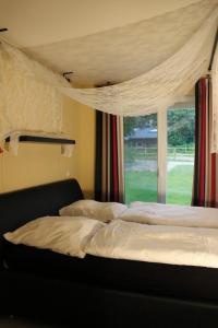 a bedroom with a bed and a window with curtains at Kamaahr in Friedenstal