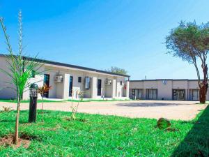 un edificio con un árbol en el césped delante de él en Mganwini Lodge, en Siweni