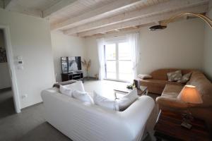 - un salon avec un canapé blanc et une table dans l'établissement Penthouse "LaBella" V5W7, à Dierhagen