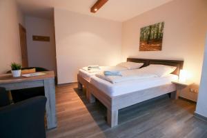 sypialnia z 2 łóżkami, biurkiem i stołem w obiekcie Familienhof Brüning - Doppelzimmer Waldesruh II w mieście Meppen