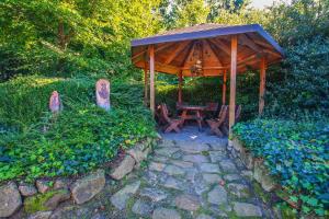 a wooden pavilion with a table and chairs in a garden at Familienhof Brüning - Doppelzimmer Waldesruh II in Meppen