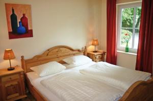 um quarto com uma cama com lençóis brancos e uma janela em Ferienhof Rauert Haus 1 em Todendorf auf Fehmarn
