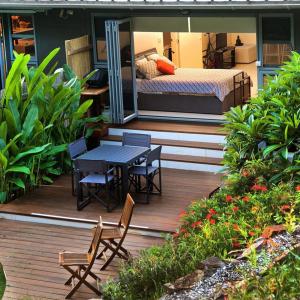 a wooden deck with a bed and a table and chairs at Driftwood Villa's - Scotts Head in Scotts Head