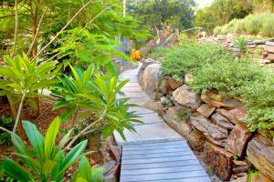 a garden path with a stone wall and plants at Driftwood Villa's - Scotts Head in Scotts Head