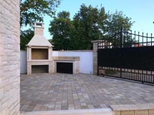 a brick patio with a fireplace and a fence at Villa Bavaria Porec in Rošini