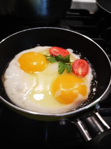 a frying pan with eggs and strawberries on a stove at Заміський будинок Fresh air in Vinyntsi