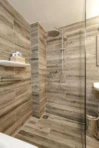 a bathroom with a shower with wooden walls at Aris Amsterdam in Amsterdam