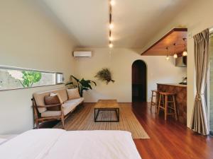 a bedroom with a bed and a living room at IMAGINE OKINAWA -stay- in Nakijin