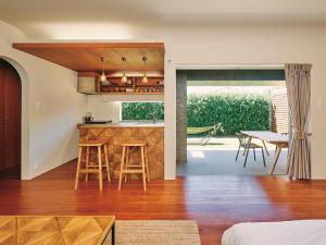 a kitchen and living room with a table and chairs at IMAGINE OKINAWA -stay- in Nakijin