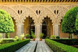 an ornate building with a courtyard with bushes and trees at apartamento centro historico Zaragoza in Zaragoza