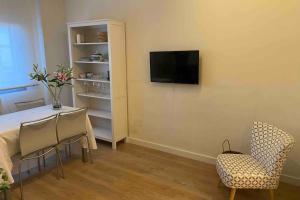 a living room with a table and chairs and a television at apartamento centro historico Zaragoza in Zaragoza