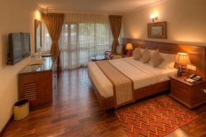 una camera d'albergo con un grande letto e una TV di Fish Tail Lodge a Pokhara