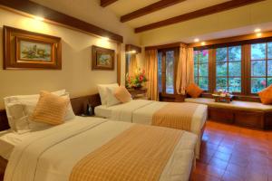 um quarto de hotel com duas camas e um banheiro em Fish Tail Lodge em Pokhara