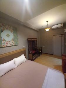 a bedroom with a white bed and a room with a table at Buri Hostel Bangkok in Amphoe Phra Khanong