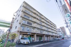 a large apartment building with a white van parked in front of it at stay's ジローズ浄心 601号 名古屋 民泊 駅近 in Nagoya