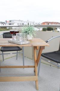 une table en bois avec une plante sur un balcon dans l'établissement "Haus Wiking - Whg 14" - strandnah und ruhig gelegen, à Grömitz