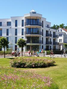 a large white building with people riding bikes in a park at Apartment Nordstern in Baabe