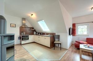 uma cozinha e sala de estar com um sofá vermelho em Villa Carpe Diem, FW 9 em Zingst