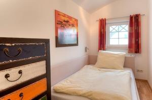 um pequeno quarto com uma cama e uma janela em Villa Carpe Diem, FW 9 em Zingst