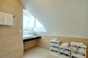 uma casa de banho com um lavatório, uma janela e cestos em Villa Carpe Diem, FW 9 em Zingst