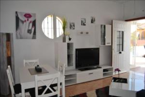 een woonkamer met een tv aan een witte muur bij Casa Aurelia in Mazarrón